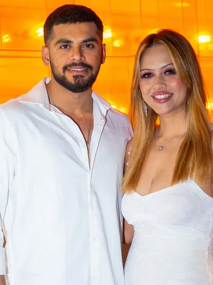 A happy couple posing for a photo against the warm, ambient lighting.