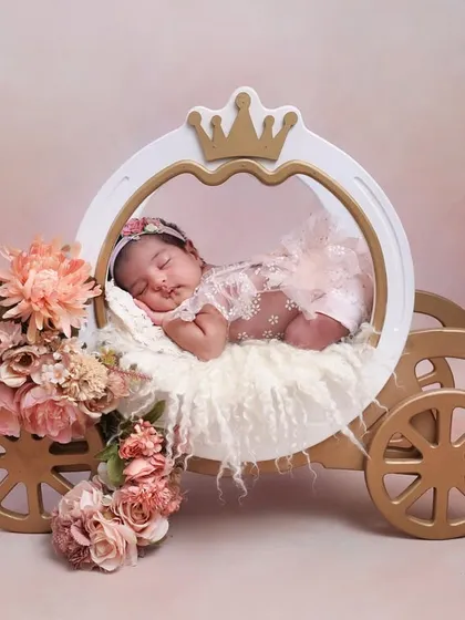 A sleeping beauty in her carriage. This angle showcases the beautiful details of the princess carriage and the delicate floral arrangements, creating a truly royal portrait.