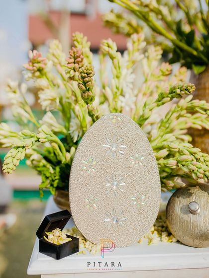 An elegant decor piece featuring a sparkling egg-shaped object and a small box of jasmine, adding a touch of whimsy.