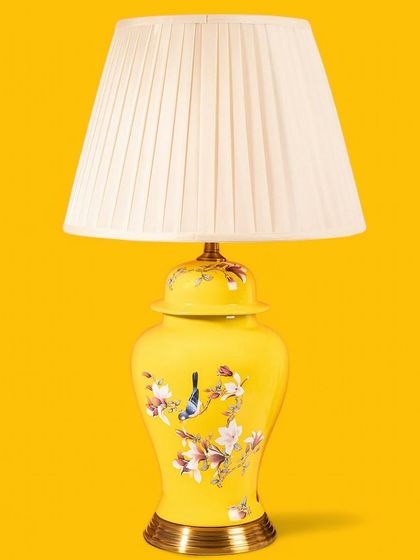 This cheerful yellow ginger jar lamp is perfect for adding a pop of color to a room. The base is adorned with delicate hand-painted birds and flowers, and the pleated white shade keeps the look fresh and bright.
