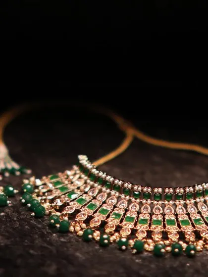 A detailed shot of a beautiful bridal necklace set with green stones. This photo highlights the intricate craftsmanship of the wedding jewelry.