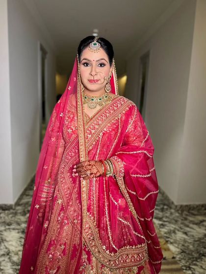 A beautiful bride ready for her special day. Her makeup is classic and radiant, with a pop of pink on the lips to match her stunning lehenga.