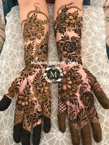 A stunning example of how to use black henna for bold outlines and regular henna for filling, creating a beautiful contrast.