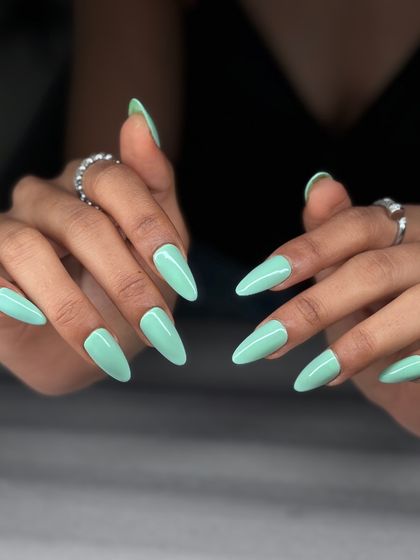 A fresh and modern look featuring a beautiful pastel mint green on long stiletto nails. It's a perfect pop of color for spring and summer.