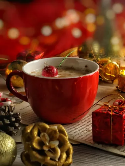 A close-up of the red mug from the Christmas flat lay, with beautiful bokeh lights in the background creating a magical holiday mood.