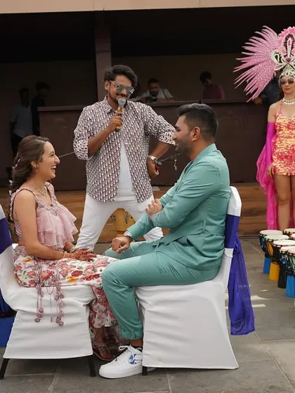 A fun, interactive moment with the couple during their carnival-themed party in Goa, complete with djembe drums and vibrant performers.