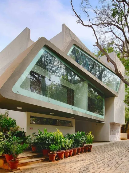Our landscape design for this architecturally significant residence, known as the Mobius house, involved carefully preserving existing trees and using container planting to soften the entrance, ensuring the futuristic facade remains connected to its natural setting.