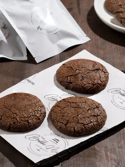 Freshly baked chocolate cookies on a branded sheet. This shot is great for showing the product in a "fresh from the oven" context.