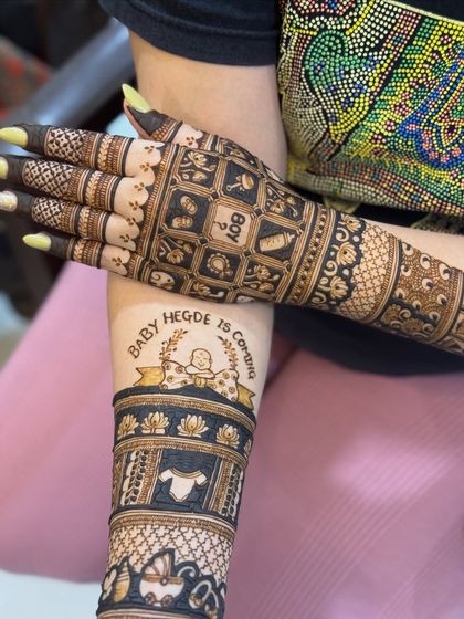 A side view of the baby shower mehendi, showing the detailed bands on the arm with baby-themed patterns.