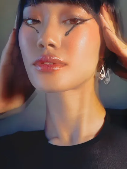 Let the eyes do the talking. This creative look features a unique, artistic eyeliner design, proving that makeup can be a true form of expression.