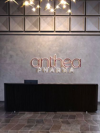 A close-up of the reception area, highlighting the custom-designed square concrete panels and the company's brightly colored logo. This detail symbolizes the blend of craftsmanship and corporate identity.