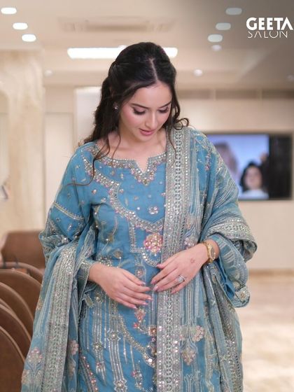 The half-up, half-down hairstyle with loose waves adds a touch of modern elegance to the traditional outfit.