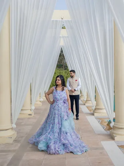 A dreamy pre-wedding photo in a beautiful floral gown. The makeup is soft and ethereal, with pastel tones to match the dress.