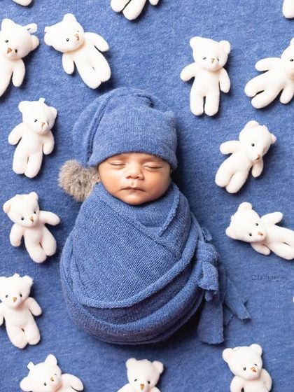 Simple elegance never fades. This classic newborn portrait, with a blue wrap and hat surrounded by tiny teddy bears, will be cherished forever.