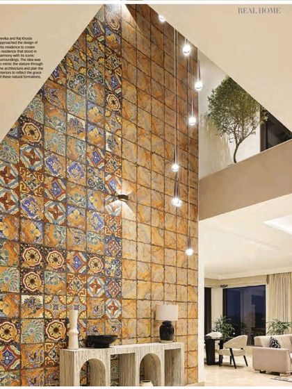 The atrium at Terra is the heart of the home. We designed this double-height space with a feature wall of handmade tiles, whose earthy tones echo the Chambal landscape. The cascading lights draw the eye upward, celebrating the volume and stillness of the entrance.