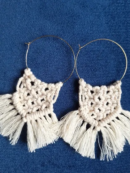 For those who love a bohemian touch, I create these macrame hoop earrings. I use classic macrame knots and finish them with a soft fringe, all attached to a simple hoop. They are a beautiful example of wearable fiber art.