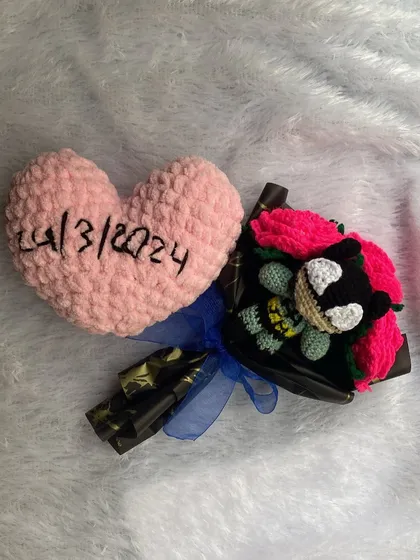 This was a very special custom order. It includes a small character bouquet and a soft, crocheted pink heart embroidered with the date "24/3/2024" to mark a special occasion.