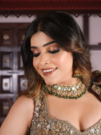 Let the eyes do the talking. A close-up of the golden glittery eye makeup, paired with a glossy brown lip and soft waves.