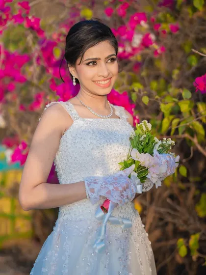 The bride against a backdrop of vibrant flowers. Her makeup is kept neutral and elegant to complement the colorful surroundings.