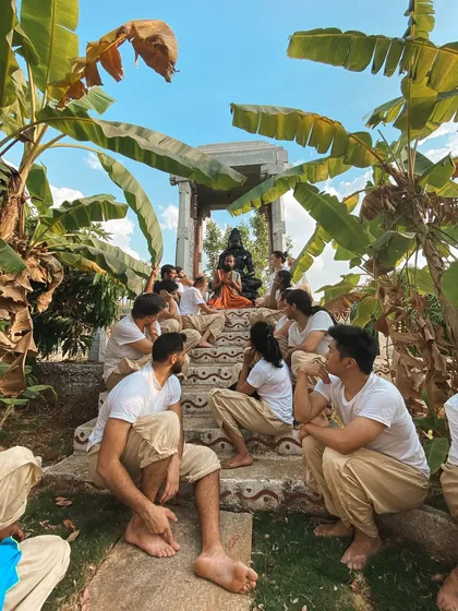 This is a duplicate of image 87, capturing a moment of teaching at the outdoor shrine, where students listen with rapt attention.