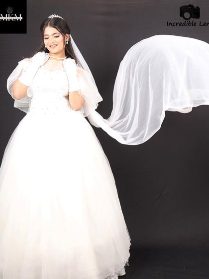 A dramatic shot with the veil in motion. The makeup remains the focal point, looking clean and elegant against the flowing white fabric.