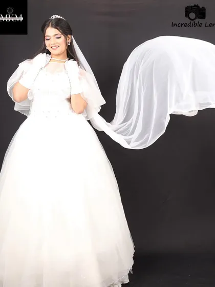 A dramatic shot with the veil in motion. The makeup remains the focal point, looking clean and elegant against the flowing white fabric.