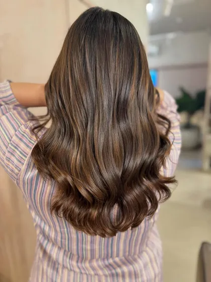 Another angle of the 'Rich Roast' non-bleach color, showcasing its incredible shine and the soft, flowing waves that enhance the dimensional tones.