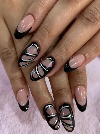 A modern and edgy design with a black French tip and abstract silver and black lines creating a butterfly wing effect.