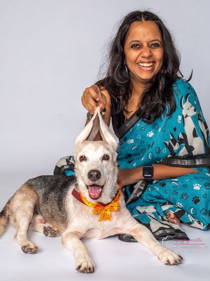 A playful and happy studio portrait of Kavitha holding her beagle Seenu's ears. This shot perfectly captures their fun-loving relationship.