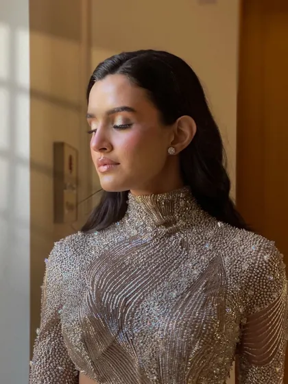 An artistic shot of the model. The light catches the shine on her perfectly styled waves.