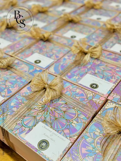 A large batch of our Diwali hampers featuring a unique holographic and pastel mandala design. Each box is tied with a shimmering gold ribbon and a custom tag, ready to deliver festive cheer for a large corporate order.