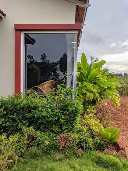 A carefully planned garden bed sits just outside a large window, bringing the beauty of nature right up to the house. This ensures the garden can be enjoyed from both inside and out.