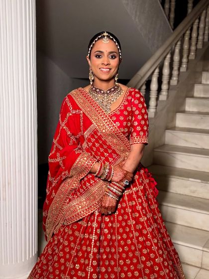 A full-length view of the royal bride. The entire look, from the sleek matha patti to the grand lehenga, is a vision of grace and tradition.