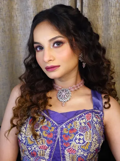 A portrait of the model showing off the complete Haldi and Mehndi look, with her colorful outfit and glamorous makeup.