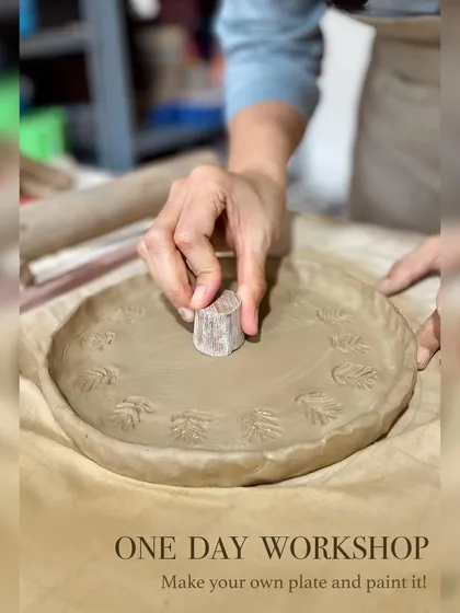 Beyond the wheel, hand-building opens up a world of possibilities. Here, a student uses a simple wooden stamp to add a personal, leafy texture to a plate made using the slab technique.