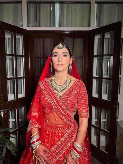 The pure, uninhibited joy of a bride. Vittoria's laughter is infectious, and her classic red lehenga and elegant makeup complete this perfect wedding day picture.
