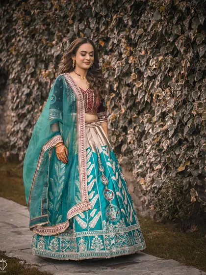 A full-length shot of the bride in her stunning turquoise and maroon lehenga, perfect for a Sangeet or reception night.