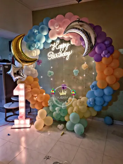 A dreamy "Twinkle Twinkle Little Star" theme for a first birthday. This home setup features a balloon ring with moon and star foil balloons, a neon sign, and a light-up number '1'.