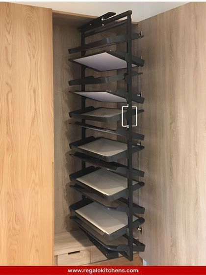 This vertical pull-out unit features multiple trays, offering a versatile storage solution for folded items, accessories, or even documents within a wardrobe.