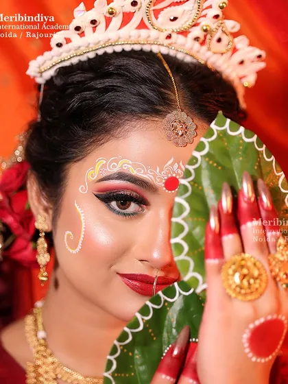 A classic pose from our Bengali bride photoshoot, highlighting the dramatic winged eyeliner and intricate forehead design that are hallmarks of this look.