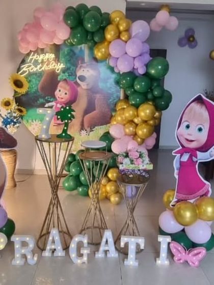 A charming Masha and the Bear themed birthday party, perfect for a home setting, with character cutouts and a jungle-like balloon garland.
