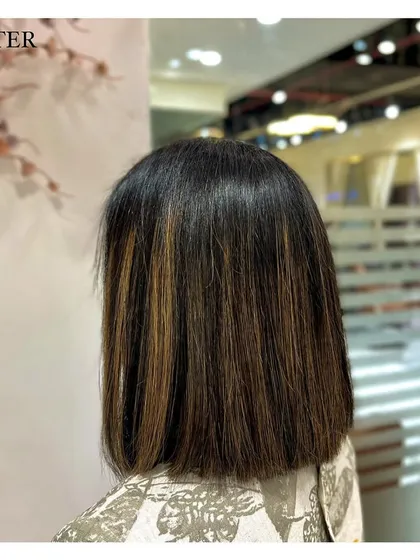 This client opted for a chic blunt haircut with some subtle brown highlights. The straight styling emphasizes the clean lines of the cut and the dimension of the color.
