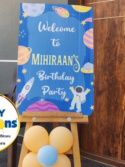 A personalized welcome sign for a space-themed first birthday, featuring astronauts, rockets, and planets.