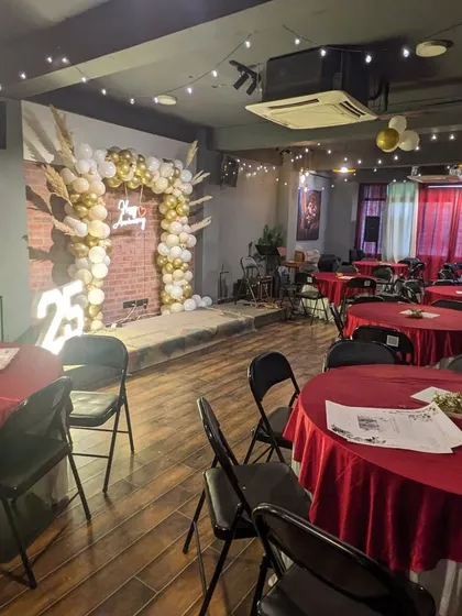 This image shows how the anniversary backdrop integrates into the larger party venue, creating a dedicated stage for the guests of honor.