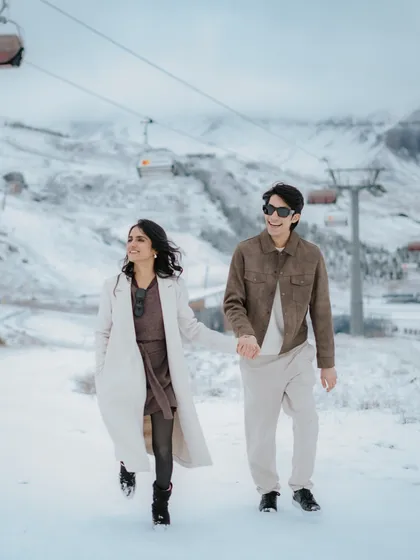 Walking hand-in-hand through the snow, with the ski-lifts of Azerbaijan in the background. This image tells a story of adventure and companionship, set against a magnificent mountain landscape.