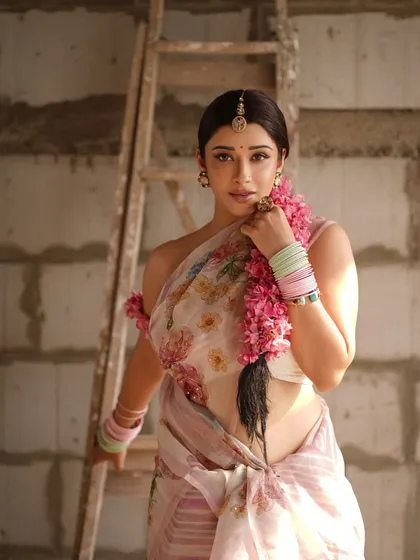 A confident and direct pose, where the floral braid becomes a central element of the composition. The styling is both traditional in its elements and modern in its attitude.