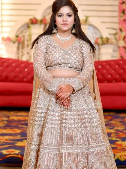 The full view of the elegant party look. The makeup is kept soft and glowing to balance the heavily embroidered outfit.