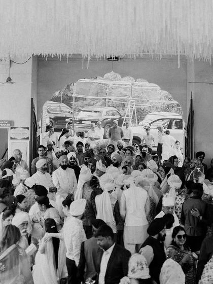 The bustling, joyful atmosphere of a Gurudwara wedding. This black and white shot captures the community and energy surrounding the couple on their special day.