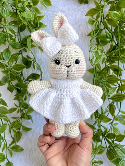 A pure white bunny doll, made as a special gift for a Holy Communion ceremony. Her simple white dress gives her a sacred and peaceful look.