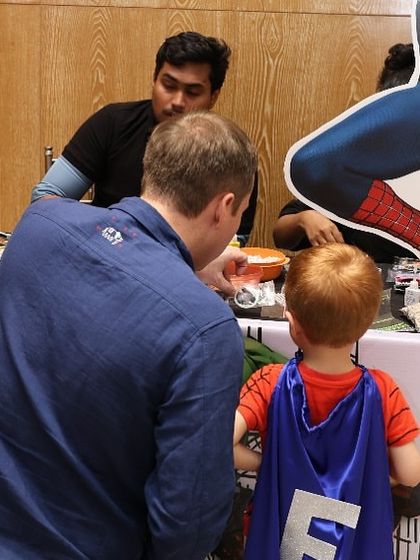 A father and son moment at the craft table, choosing accessories for their superhero gear. My events are designed for family enjoyment.